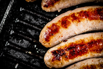 Grilled sausages in a frying pan. 