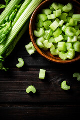 Sliced fresh celery. On a dark wooden background.