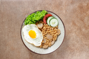 Nasi Goreng Bakso is Fried Rice with Meat Ball garnished with fresh cucumber and tomatoes slices.