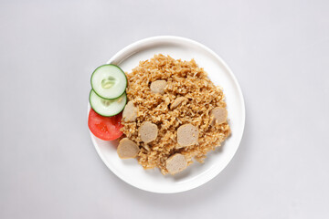 Nasi Goreng Bakso is Fried Rice with Meat Ball garnished with fresh cucumber and tomatoes slices.