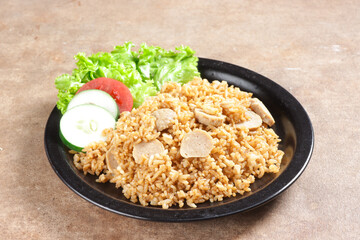 Nasi Goreng Bakso is Fried Rice with Meat Ball garnished with fresh cucumber and tomatoes slices.