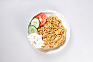 Nasi Goreng Ayam is Fried Rice with chicken meat garnished with fresh cucumber and tomatoes slices.