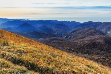 Mountain peaks of the Caucasus on a sunny day. View from a height of 1000 m. View of the ridge of mountain peaks from a height. A magnificent mountain range with high peaks. 
