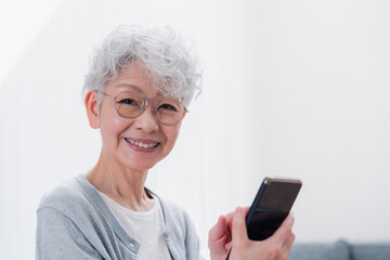 笑顔でスマホを操作するシニアの女性