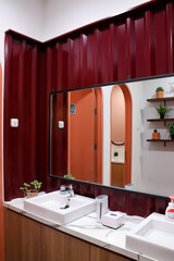 Interior of modern bathroom with opened doors and illuminated shiny walls in restaurant 