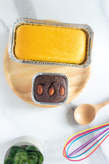 Butter cake and brownie on round wooden plate on marble desktop