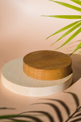 Empty wooden podium beige background. Product presentation with tropic tree leaves and shadows.