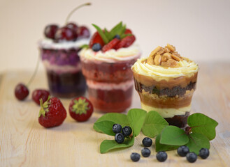 Homemade desserts in glass jars. Traditional unbaked Italian dessert on a white background. Cake with coffee, berries, fruits and mascarpone cream.