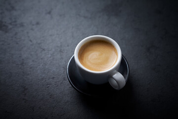 Cup of coffee on dark stone background. Close up. Copy space. 