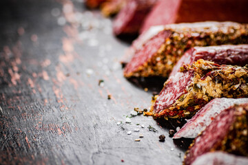 Various salami sausage on the table in a row. 