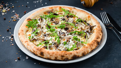 Italian pizza with mushrooms, goat cheese, parmesan and arugula on a thick dough with spices.