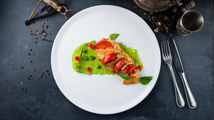 Chicken fillet with tomatoes and spinach puree and basil.