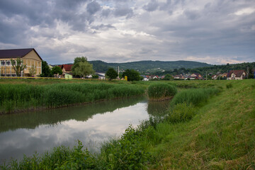 Fototapeta na wymiar Romania, Bistrita, Houses and blocks nearb the Bistrita River in June 2022