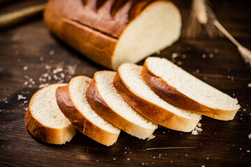 Sliced wheat bread. On a wooden background.