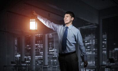 Fototapeta premium Happy businessman holding glowing lantern