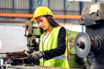 Professional labor machanic engineer technician woman industrial wearing safety uniform working control with heavy machine in manufacturing  factory production line.business industry