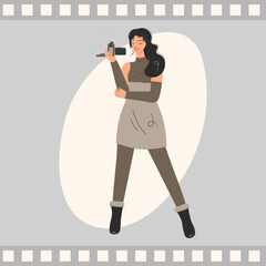 The girl holds the camera, takes a photo or video. Young director in a retro studio. Attractive film industry woman, video production flat style vector illustration.