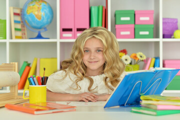 little girl studying at home at the table