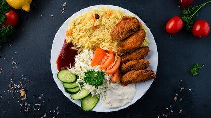 Chicken wings with rice, tomatoes, cabbage, cucumbers, ketchup and mayonnaise.