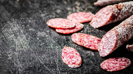 Sliced delicious salami sausage. On a black background.