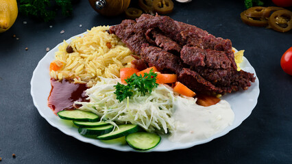 Fried beef with rice, tomatoes, cabbage salad, cucumbers, ketchup and mayonnaise.