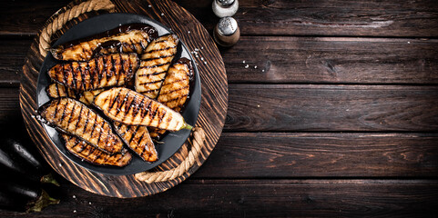 Eggplant grilled in a plate on a wooden tray. 