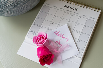 Mothers day reminder calendar with pink roses. March calendar placed on a table with focus on the...