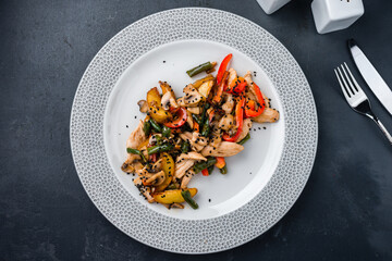 Chicken with green beans, sweet peppers, champignons, potatoes, sesame in soy sauce.
