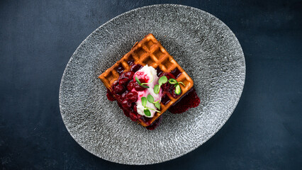 Breakfast Belgian waffles with cream cheese and cherry jam.