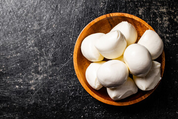 Mozzarella cheese in a wooden plate on the table. 