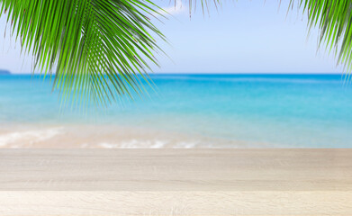 Empty wooden table with palm leaves and beach sea sky background , using for studio background and product display summer and presentation concept