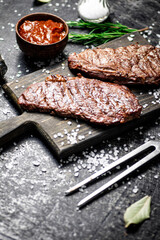 Grill steak on a wooden cutting board.