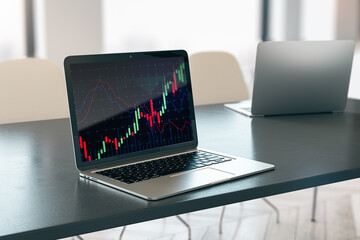 Close up of laptop on desktop with glowing forex chart on blurry background. Trade, finance and invest concept. 3D Rendering.