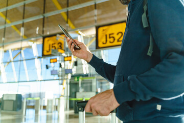 Close-up of caucasian young man hands typing on phone at airport boarding gate