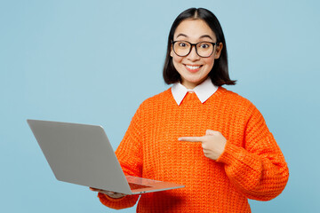 Young happy smart IT woman of Asian ethnicity wear orange sweater glasses hold use work point...