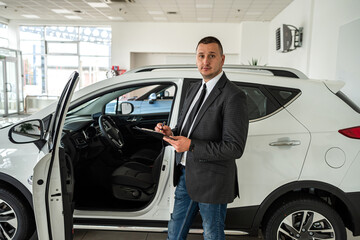 Fototapeta na wymiar Man customer buyer in suit choosing best new car at dealership