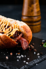 Hot dog with sausage, fried onions and mayonnaise, closeup.