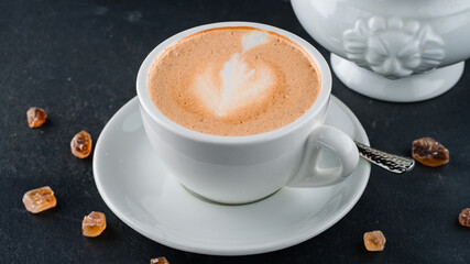 A cup of hot cappuccino coffee with sugar. - 563837802