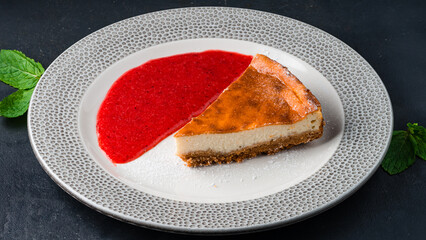 Piece of cheesecake with fresh berry sauce.