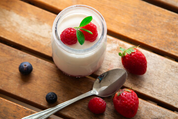 Greek yogurt with blackberries and strawberries on wood