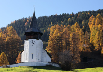 Reformierte Kirche church in the autumn Alps. Amazing landscape with small chapel on sunny meadow at Davos Frauenkirch, Davos, Switzerland