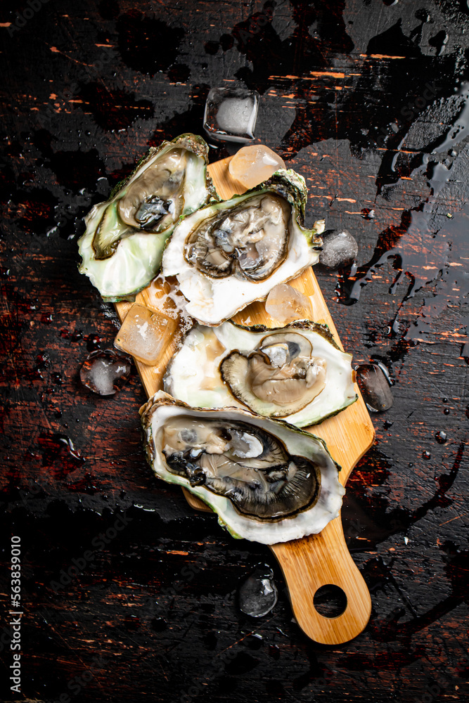 Sticker Oysters on a wooden cutting board. 