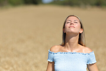 Woman breathing fresh air in a golden field
