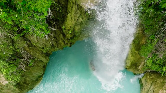 Aerial drone of waterfall in slow motion. Inambakan Falls in the green forest. Cebu, Philippines.