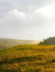 Stormy couds and sunset sky over fields.