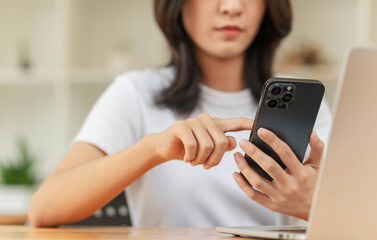 Lifestyle and technology concept, Young Asian woman using smartphone to working online at home.