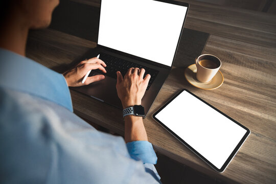 Man working on his laptop and tablet with blank white screen. Laptop and tablet mockup