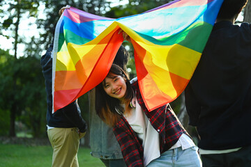 Group of young activist with pride rainbow flag, love symbol of LGBT community, diversity and human rights concept