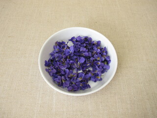 Obraz na płótnie Canvas Freshly picked sweet violets in a shallow bowl