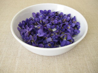 Obraz na płótnie Canvas Freshly picked sweet violets in a shallow bowl